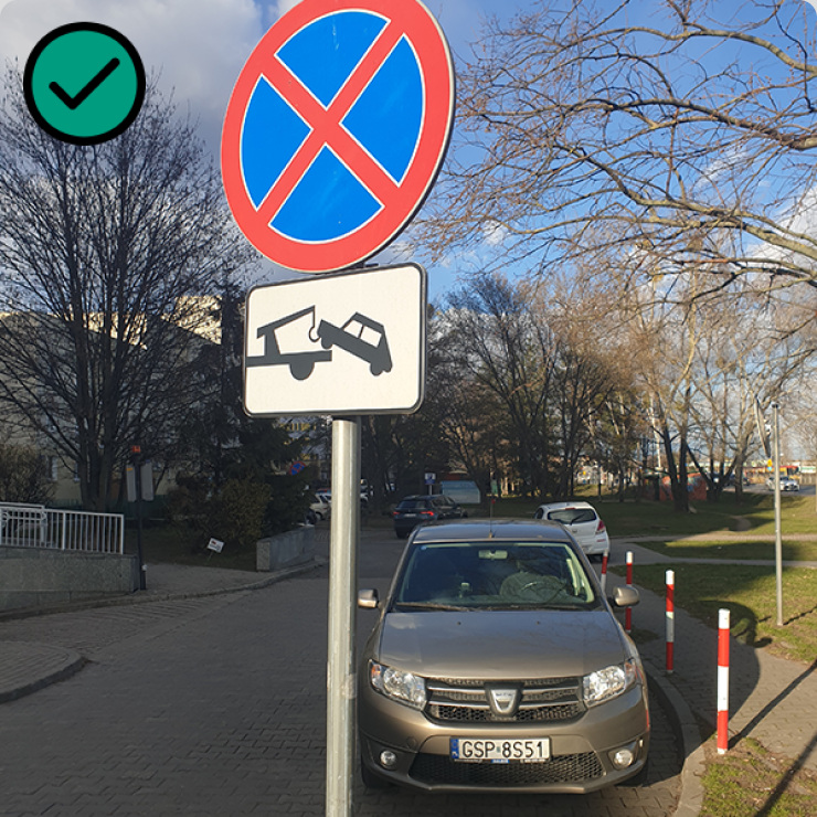 Zdjęcie pojazdu stojącego za znakiem B-36 zakaz postoju i zatrzymywania wraz z tabliczką oznaczającą odholowywanie pojazdów.
